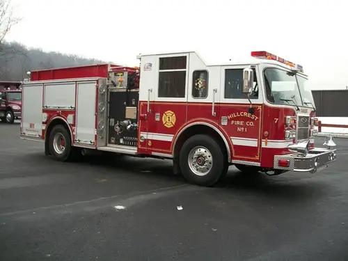 Front right exterior view of the tanker-style pumper with chrome bumper, cab, and pump panel area visible.