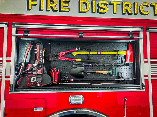 Open side compartment showing hand tools and rescue gear in horizontal racks