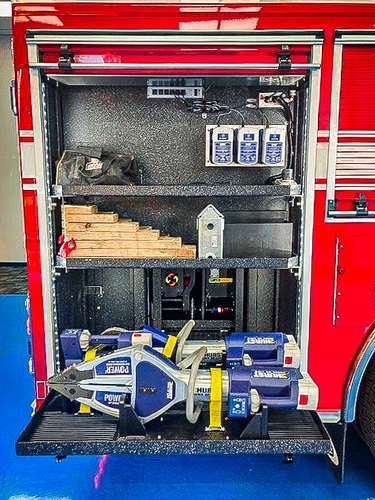 Open side compartment showing portable saw and tool storage shelves