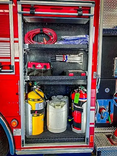 Open side compartment showing extinguisher and tool storage layout
