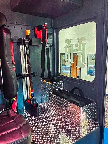Open rear cab door view showing stepwell and crew seating access