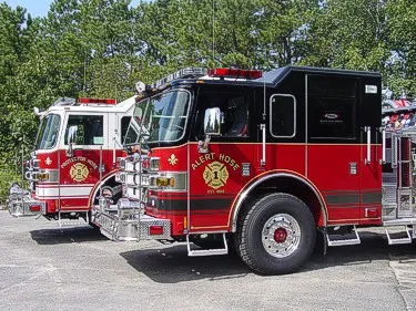 Two-apparatus lineup front-quarter view showing white and black cabs