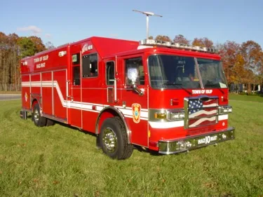 Hazmat truck front-left exterior view showing enclosed cab and long body
