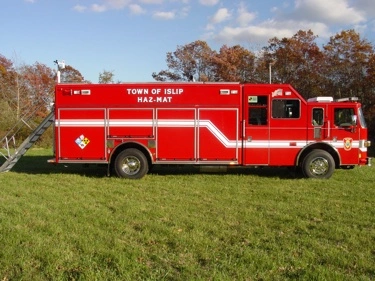Driver-side profile view showing long hazmat body and side compartments