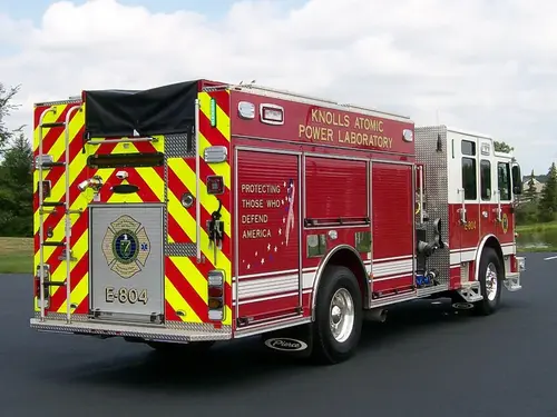 Rear-left exterior view showing chevrons, rear body, and side compartments