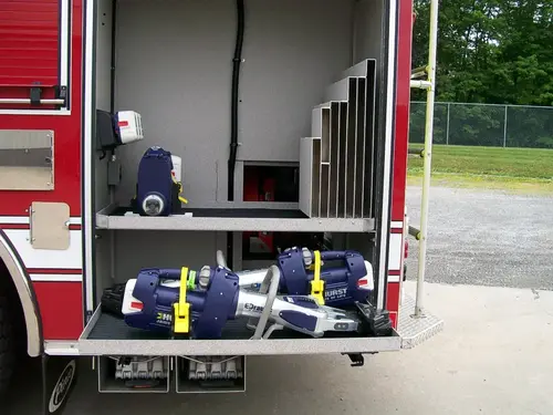 Open side compartment showing multiple strapped soft bags on pull-out tray