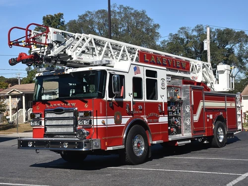 Front-left exterior view of aerial ladder truck showing cab, pump panel area, and ladder bed