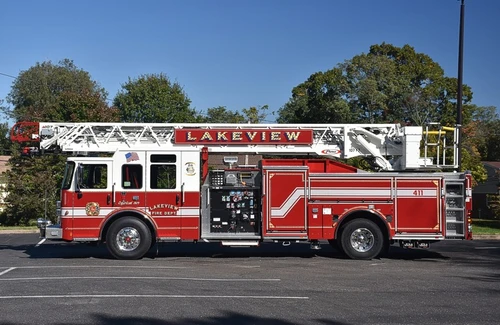 Driver-side full profile showing pump panel, side body, and rear tiller platform area
