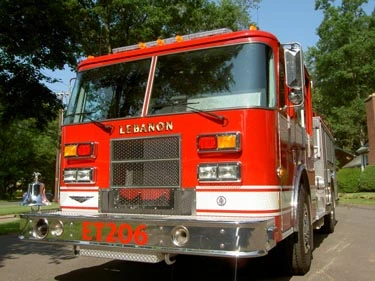 Head-on front view with chrome bumper, grille, warning lights, and front-mounted number panel.