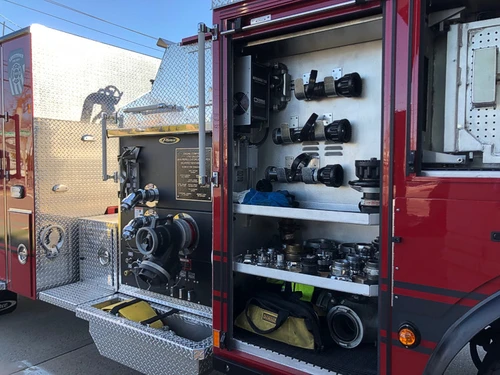 Open side compartment showing stacked equipment shelves and tool storage