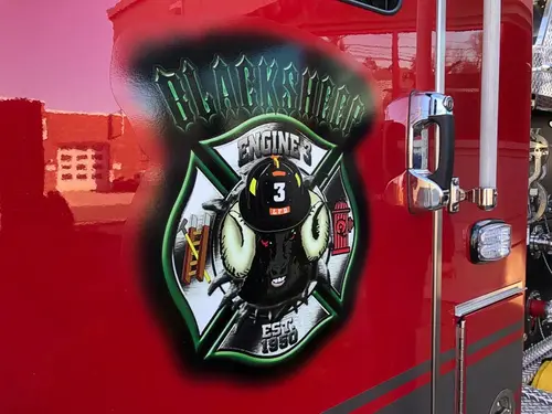 Cab door close-up showing shield-style firefighter artwork on red panel