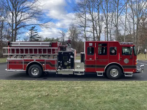 Officer-side profile view showing closed roll-up doors and pump-panel section