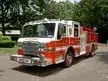 Wide front left view of the parked pumper showing cab, bumper, and full side body.