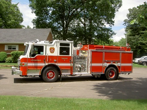 Full left-side profile showing pump panel position, compartment layout, and wheel/tire areas.