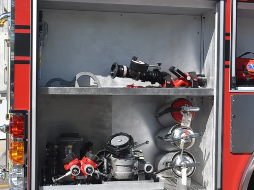 Open side compartment showing nozzles, fittings, and hardware bins