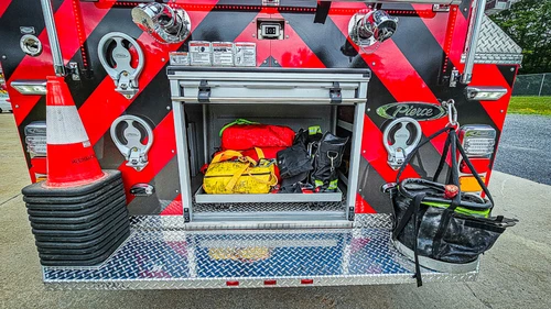 Rear center compartment close-up showing stored gear and hose nozzles