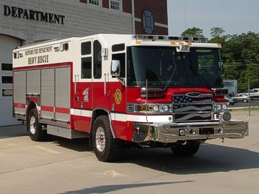 Front right angle showing the cab, chrome bumper, and rescue body compartments along the side.