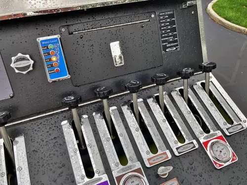 Side compartment close-up showing mounted long-handled tools and fittings