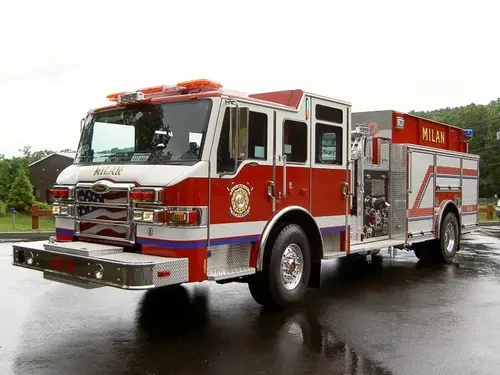 Pumper front-left exterior view on wet pavement showing cab and side compartments