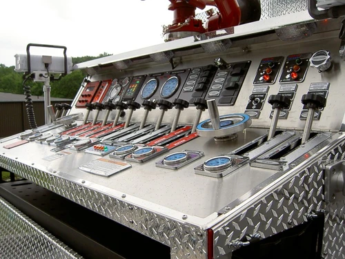 Top-mounted pump panel close-up showing gauges, switches, and control levers