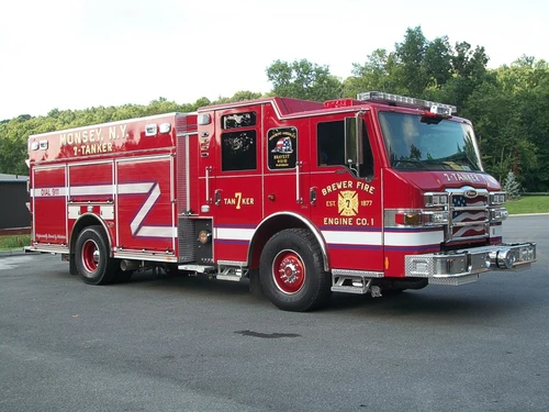 Front-right exterior view of a tanker showing the enclosed cab, side compartments, and rear body section.