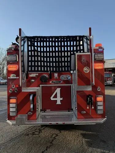 Rear view showing black-and-red chevrons, rear lights, and hosebed netting