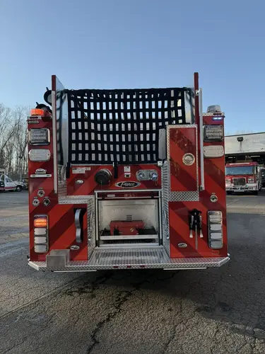 Rear view showing chevron striping, warning lights, and hosebed netting