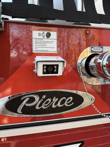 Rear panel close-up showing rear camera, Pierce badge, and discharge outlet