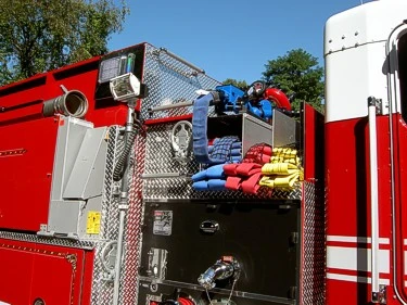 Top hosebed close-up showing folded hose bundles and intake plumbing behind cab