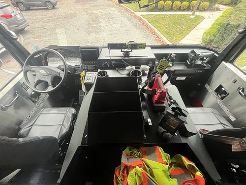 Driver cockpit view showing steering wheel, dashboard controls, and console
