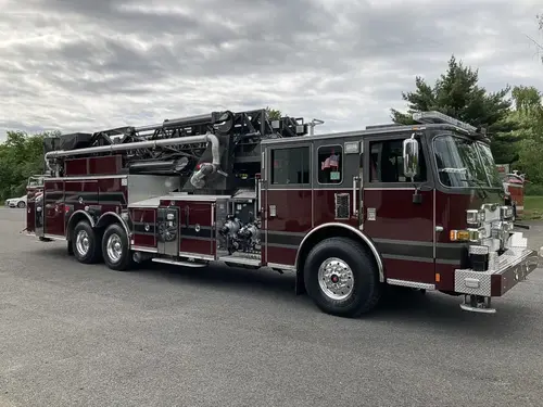 Tower ladder truck front-left exterior view showing long ladder body