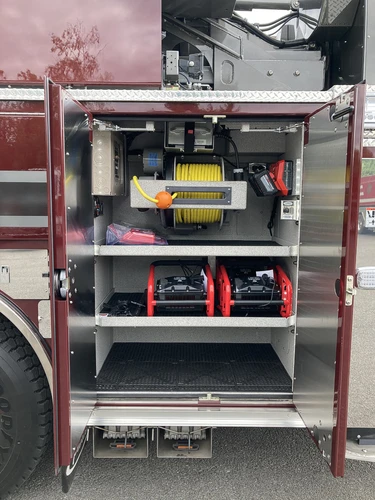 Open side compartment showing shelves with tool cases and storage bins