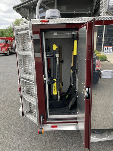Open narrow side compartment showing long-tool rack and mounts