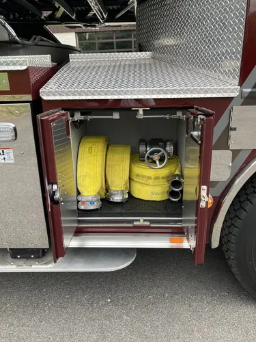 Open side compartment showing mounted yellow cylinders and tools