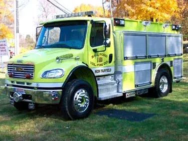 Front left exterior view of a lime-green pumper with chrome bumper, roof lights, and side roll-up compartments.
