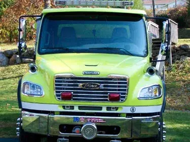 Head-on front view showing grille, windshield, warning lights, and chrome front bumper.