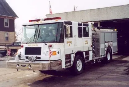Front left angle showing cab doors, bumper-mounted fittings, and left-side pump panel area.