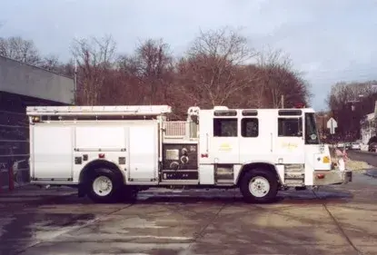Full left-side profile showing side compartments, midship pump panel, and wheel/tire layout.