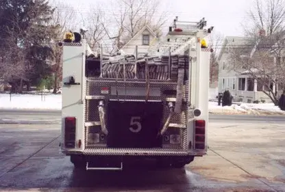 Straight rear view showing hosebed load, rear step area, and tail light assemblies.