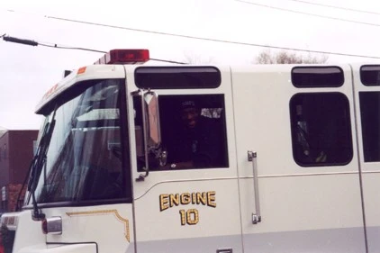 Close-up of the cab side showing officer window area, mirror, roof warning light, and unit number text.