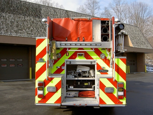 Rear view showing open hosebed, rear compartment, and chevron striping
