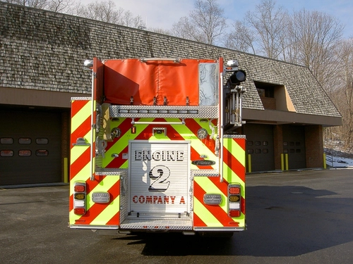 Rear view showing chevrons, hosebed opening, and rear warning lights