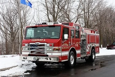 Pumper front-left exterior view in snow showing enclosed cab and side compartments