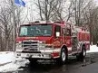 Pumper front-left exterior view in snow showing enclosed cab and side compartments