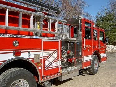 Passenger-side mid-body view showing side hosebed rails and pump fittings