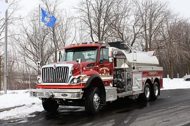 Front-left exterior view of tanker truck showing long hood cab and polished tank body