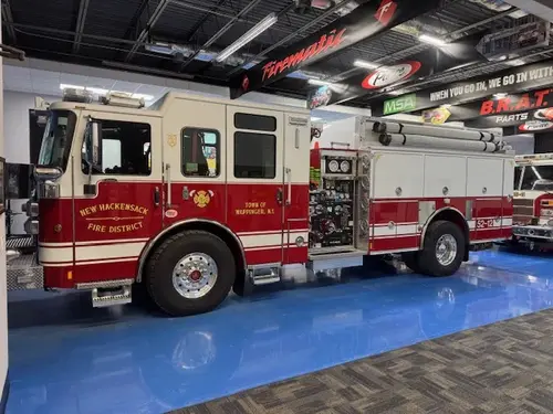 Pumper driver-side profile indoors showing side compartments and wheel area