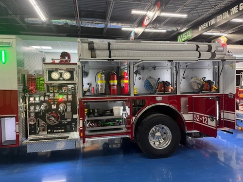 Driver-side profile with open compartments showing tools and pump controls