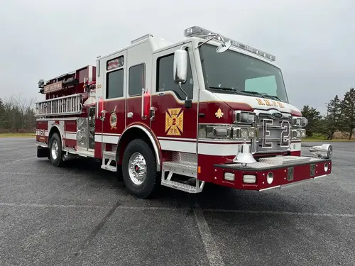 Pumper front-right exterior view showing bumper-mounted siren, grille, and crew cab