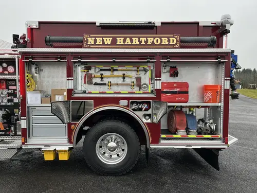 Driver-side rear compartment close-up with mounted hand tools, storage drawers, and rear wheel